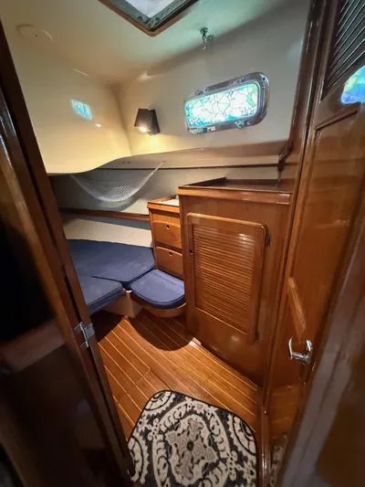 Moonsplash Yacht Photos Pics 1987 Island Packet 38 cabin interior with wooden finish, blue cushions, and decorative window.