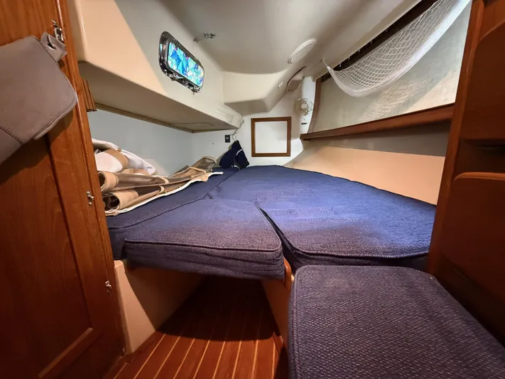 Moonsplash Yacht Photos Pics Cozy cabin interior of 1987 Island Packet 38 sailboat with blue cushions and wooden accents.