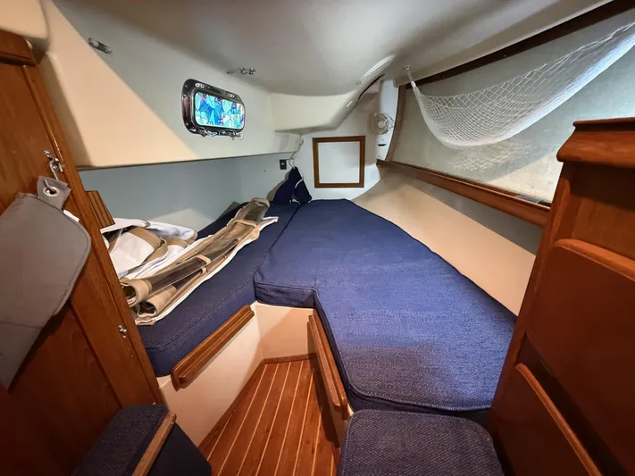 Moonsplash Yacht Photos Pics 1987 Island Packet 38 sailboat cabin with blue cushions and wooden interior.