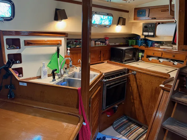 Moonsplash Yacht Photos Pics Cozy 1987 Island Packet 38 yacht kitchen with wood cabinetry, sink, and appliances.