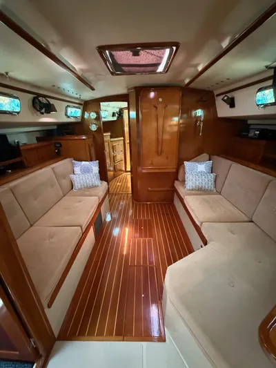 Moonsplash Yacht Photos Pics Interior of 1987 Island Packet 38 sailboat with wooden flooring and beige seating.