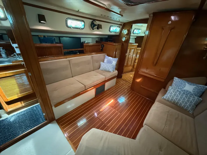 Moonsplash Yacht Photos Pics Interior of 1987 Island Packet 38 sailboat with wooden flooring and beige seating.