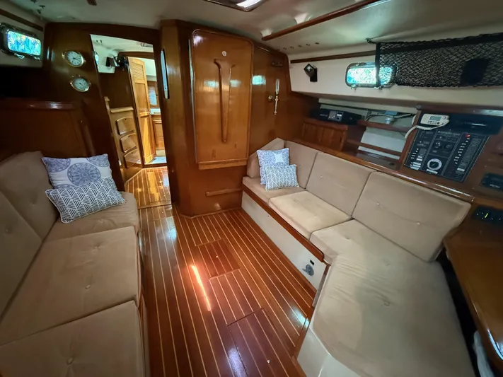 Moonsplash Yacht Photos Pics Interior of 1987 Island Packet 38 sailboat with wooden flooring and beige seating.