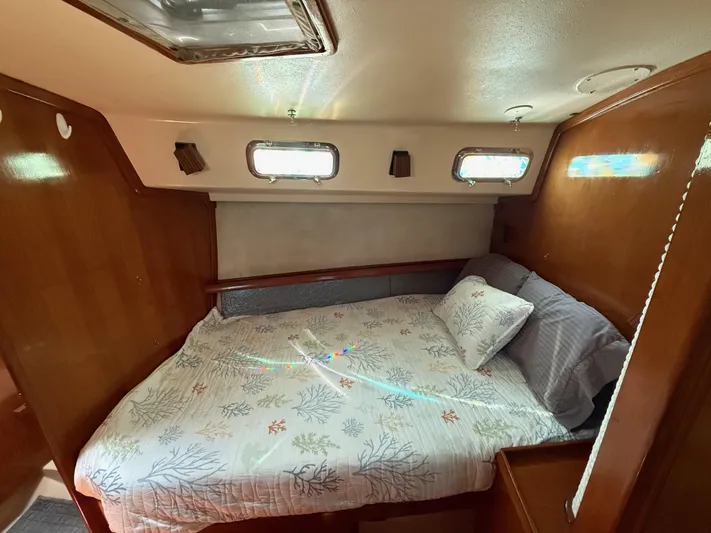 Moonsplash Yacht Photos Pics Cozy cabin interior of 1987 Island Packet 38 sailboat with comfortable bedding and wooden accents.