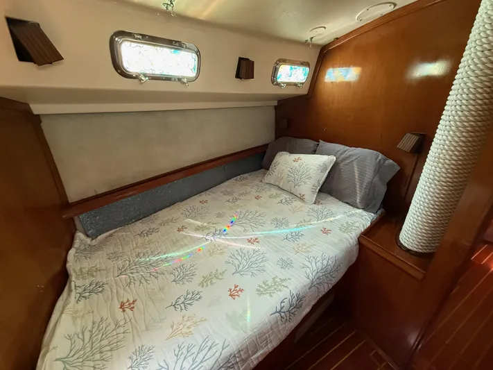 Moonsplash Yacht Photos Pics Cozy cabin interior of 1987 Island Packet 38 sailboat with nautical-themed bedding.