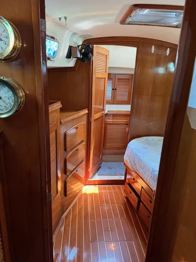 Moonsplash Yacht Photos Pics Interior of 1987 Island Packet 38 sailboat with wooden cabinetry and cozy sleeping area.