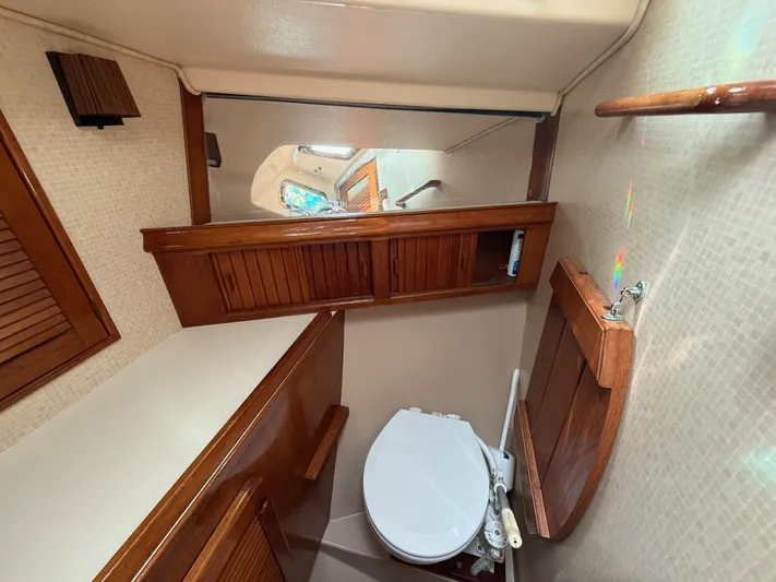 Moonsplash Yacht Photos Pics 1987 Island Packet 38 yacht bathroom with wooden cabinets and compact toilet.