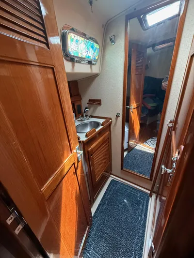 Moonsplash Yacht Photos Pics 1987 Island Packet 38 yacht interior with wooden cabinetry, sink, and mirror.
