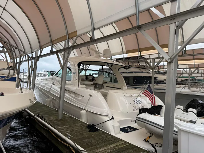 Dani Mar Yacht Photos Pics 2003 Sea Ray 500 Sundancer yacht docked under a canopy with American flag.
