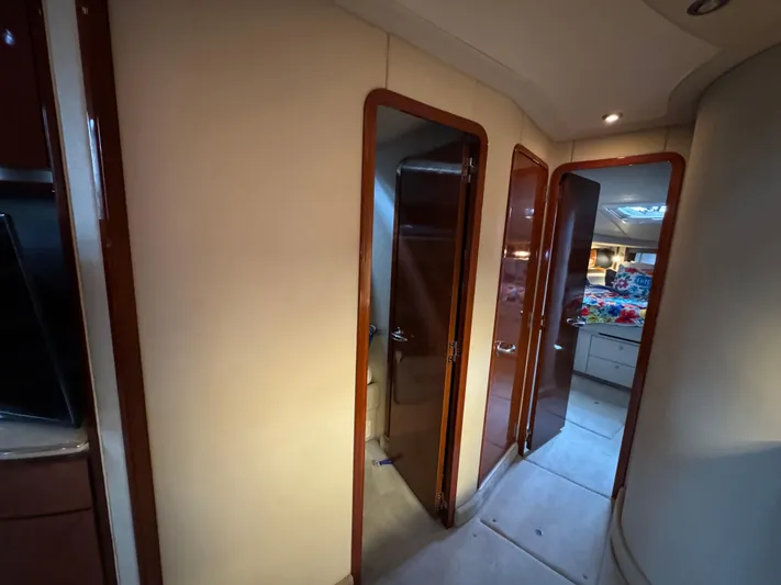 Dani Mar Yacht Photos Pics Interior hallway of 2003 Sea Ray 500 Sundancer yacht with wooden doors and cozy lighting.
