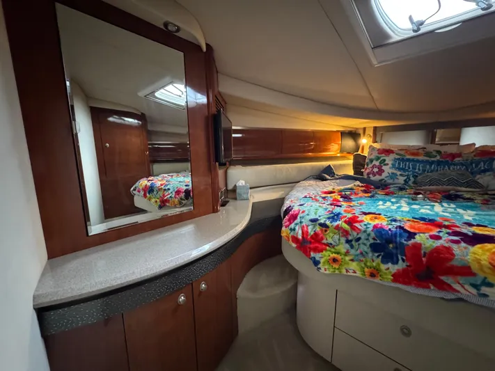 Dani Mar Yacht Photos Pics Luxurious cabin interior of 2003 Sea Ray 500 Sundancer with floral bedding and wooden cabinetry.