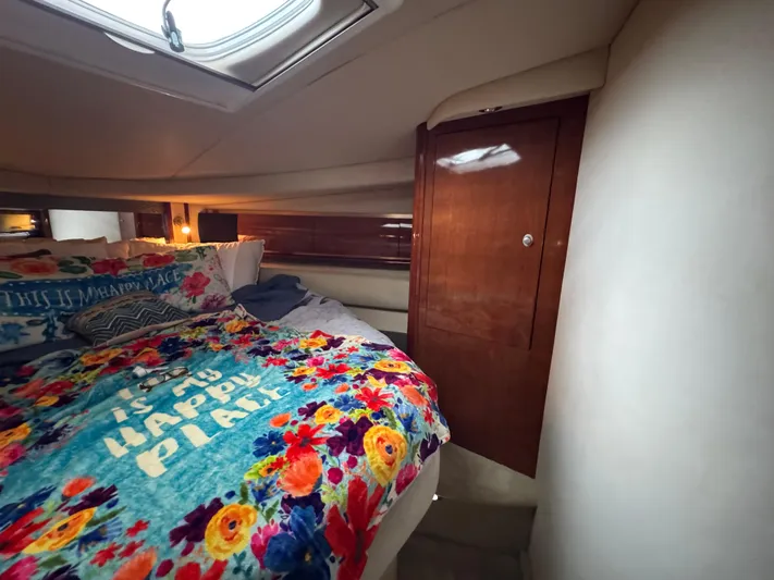 Dani Mar Yacht Photos Pics Cozy cabin interior of 2003 Sea Ray 500 Sundancer with colorful bedding and wooden cabinetry.