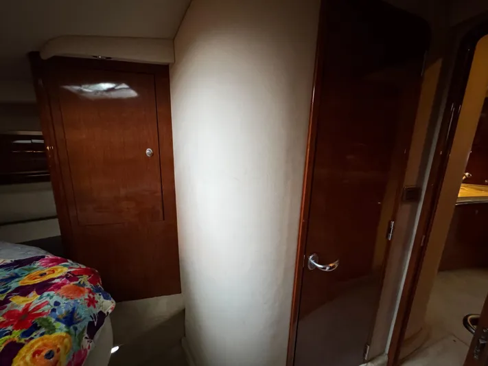 Dani Mar Yacht Photos Pics Interior of 2003 Sea Ray 500 Sundancer yacht with wooden cabinetry and colorful bedding.