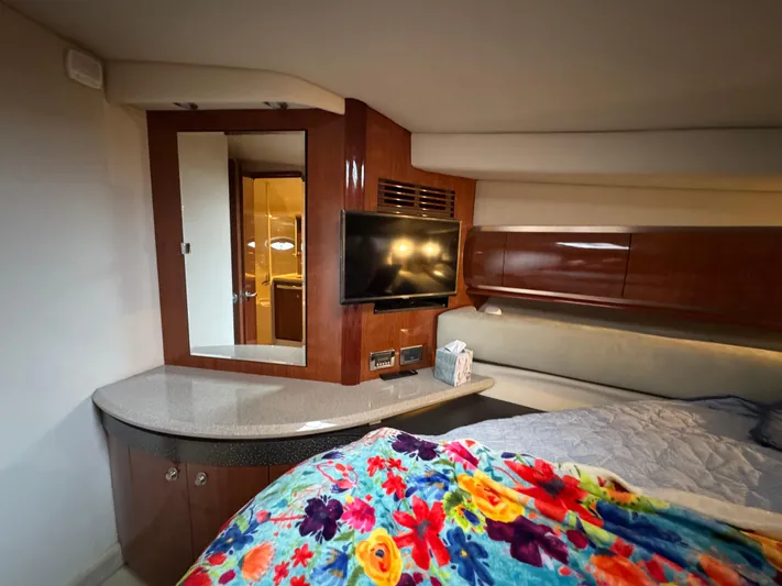 Dani Mar Yacht Photos Pics Luxurious 2003 Sea Ray 500 Sundancer cabin with TV, mirror, and vibrant floral bedding.
