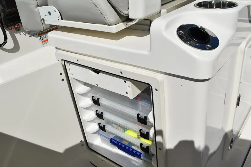  Yacht Photos Pics 2022 Pursuit S 268 Sport boat storage compartment with tackle boxes and cup holder.
