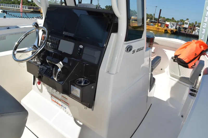  Yacht Photos Pics 2022 Pursuit S 268 Sport boat cockpit with steering wheel and control panel.