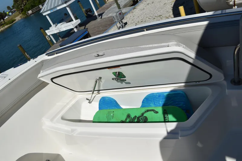  Yacht Photos Pics 2022 Pursuit S 268 Sport boat storage compartment with green and blue items inside.