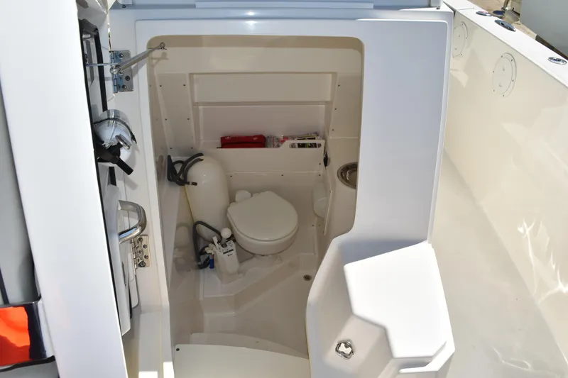  Yacht Photos Pics 2022 Pursuit S 268 Sport boat interior with compact marine toilet and storage.