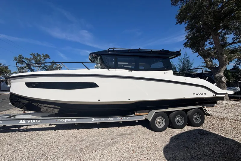  Yacht Photos Pics 2026 Navan C30 boat on trailer, sleek design, parked outdoors under clear blue sky.