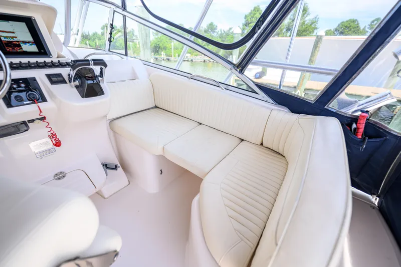 Sur Reel Yacht Photos Pics 2003 Grady-White Express 330 boat interior with white seating and control panel.