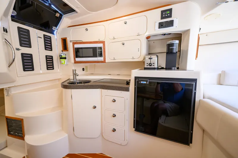 Sur Reel Yacht Photos Pics 2003 Grady-White Express 330 boat interior with kitchenette, featuring sink, microwave, and appliances.