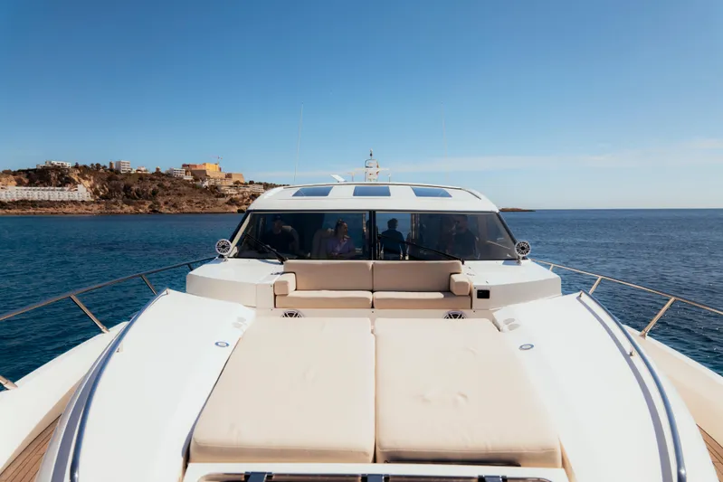 Bliss Yacht Photos Pics Luxurious 2015 Princess V72 yacht cruising on clear blue waters near a scenic coastline.