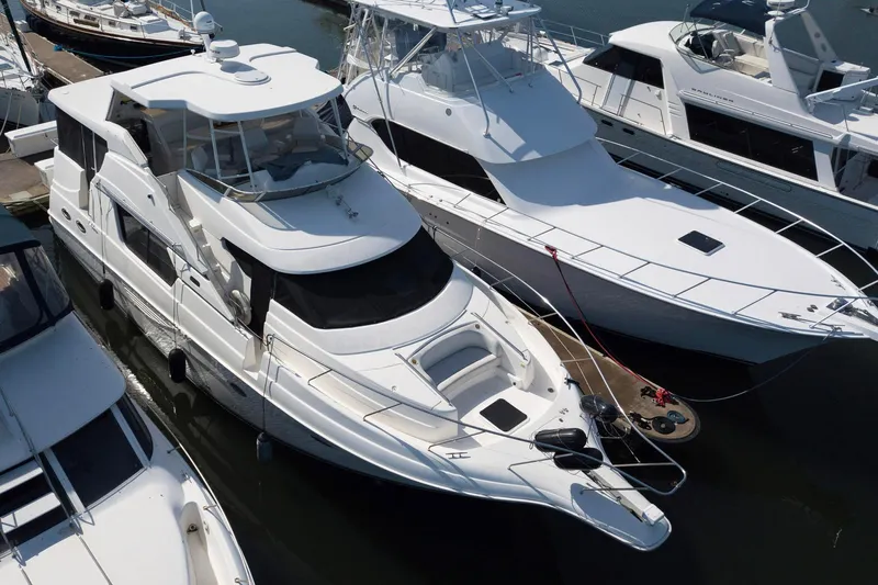 Lola's Ark III Yacht Photos Pics 2001 Silverton 453 Motor Yacht docked among other boats in a marina.