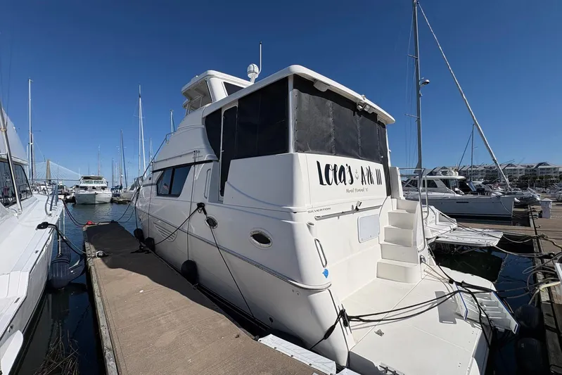 Lola's Ark III Yacht Photos Pics 2001 Silverton 453 Motor Yacht docked at marina under clear blue sky.