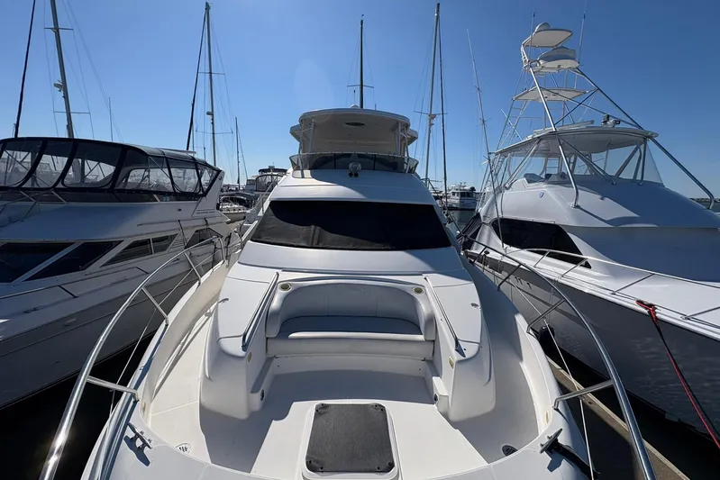 Lola's Ark III Yacht Photos Pics 2001 Silverton 453 Motor Yacht docked between two boats under clear blue sky.