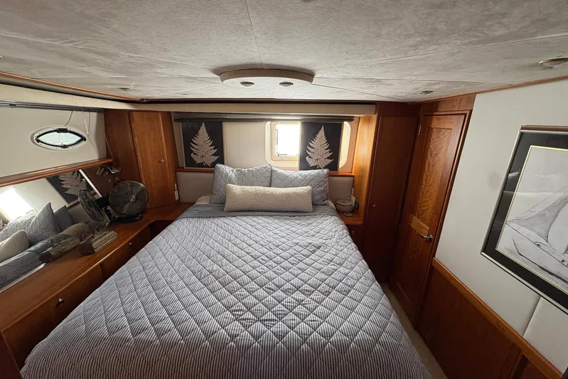 Lola's Ark III Yacht Photos Pics Luxurious 2001 Silverton 453 Motor Yacht bedroom with cozy bedding and elegant wood finishes.