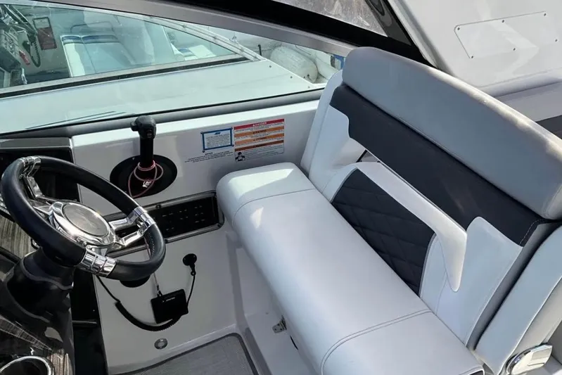  Yacht Photos Pics 2021 Monterey 295 Sport Yacht helm with sleek steering wheel and cushioned seating.