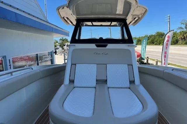  Yacht Photos Pics 2018 Chris-Craft Catalina 30 boat with cushioned seating, docked near a sales center.