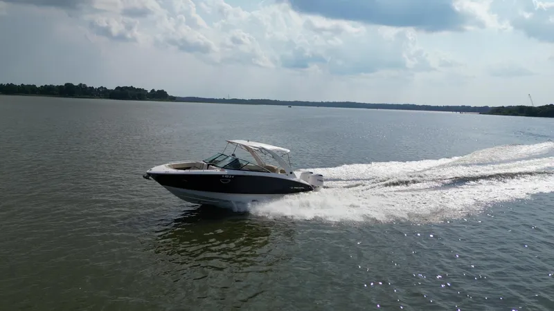  Yacht Photos Pics 2019 Regal 29 OBX boat cruising on a calm lake under a cloudy sky.