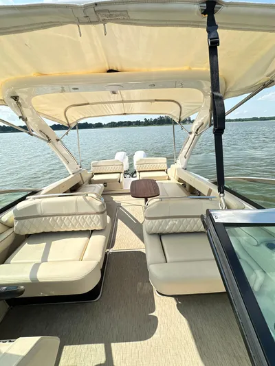  Yacht Photos Pics 2019 Regal 29 OBX boat interior with beige seating and canopy on a calm lake.