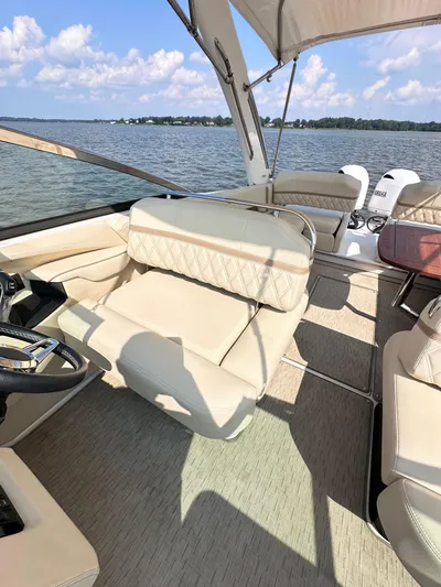 Yacht Photos Pics 2019 Regal 29 OBX boat interior with beige seating, steering wheel, and lake view.
