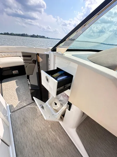  Yacht Photos Pics 2019 Regal 29 OBX boat interior with open storage compartments, on a sunny day by the water.