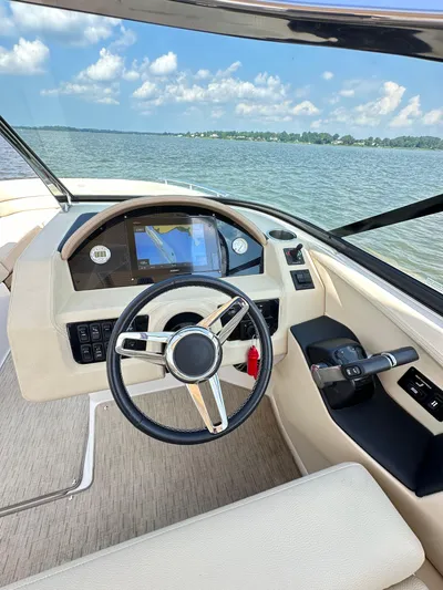  Yacht Photos Pics 2019 Regal 29 OBX boat cockpit with steering wheel and navigation system on a sunny day.