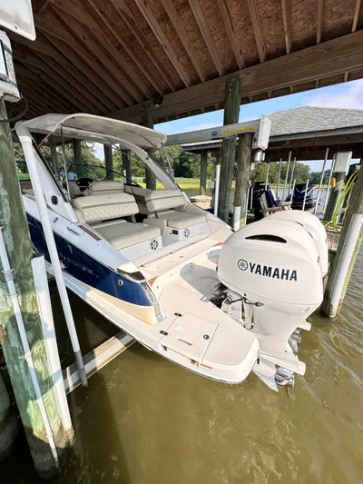  Yacht Photos Pics 2019 Regal 29 OBX boat with Yamaha outboard motor docked under a wooden shelter.