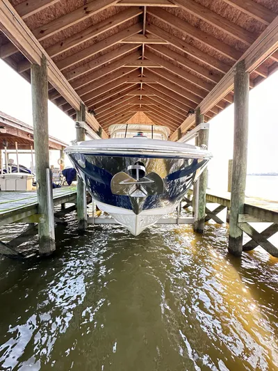  Yacht Photos Pics 2019 Regal 29 OBX boat docked under wooden shelter.