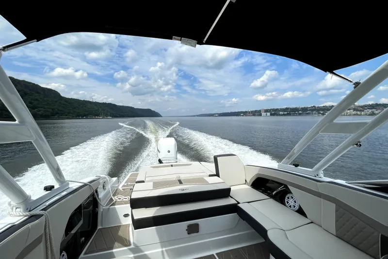  Yacht Photos Pics 2023 Monterey 275SS Super Sport cruising on a scenic waterway under a clear sky.