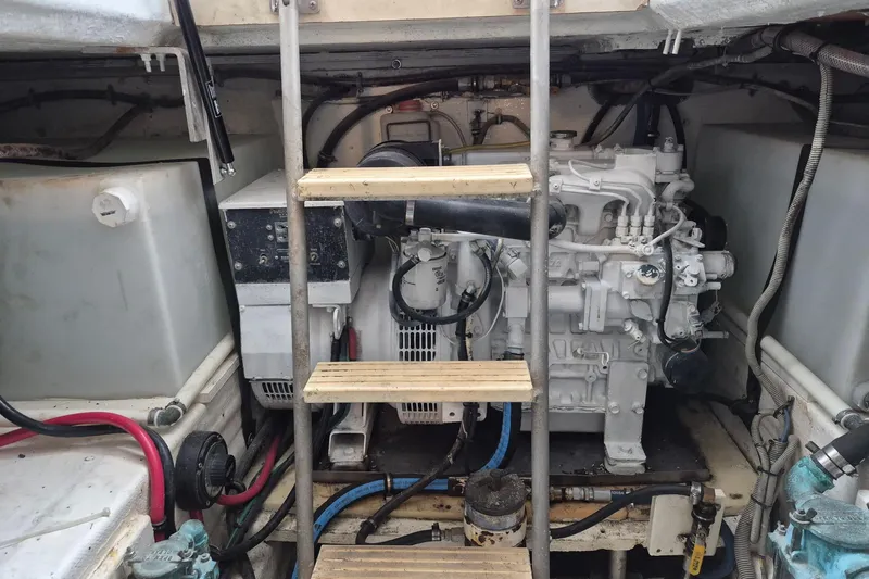 Reel Dreams Yacht Photos Pics Engine room of a 1995 Bertram 43 Convertible boat with visible machinery and ladder.
