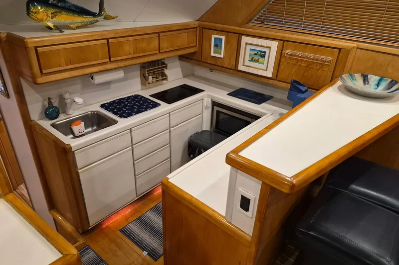 Reel Dreams Yacht Photos Pics 1995 Bertram 43 Convertible yacht kitchen with wooden cabinets and modern appliances.