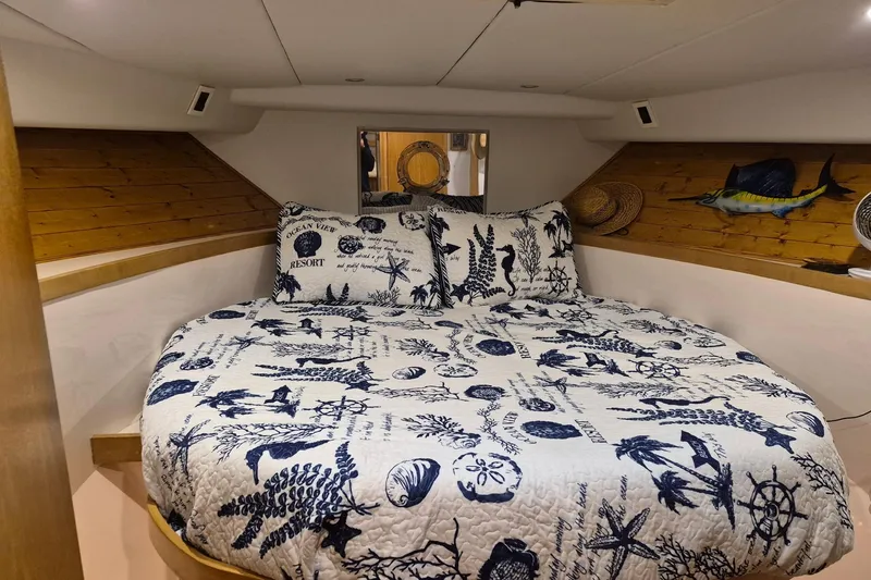 Reel Dreams Yacht Photos Pics Cozy bedroom in 1995 Bertram 43 Convertible yacht with nautical-themed bedding.