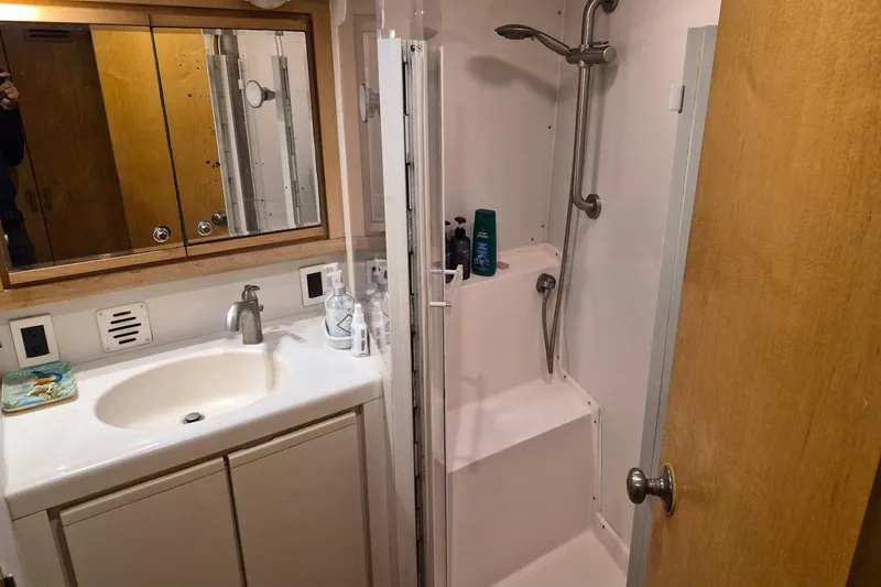 Reel Dreams Yacht Photos Pics Bathroom interior of a 1995 Bertram 43 Convertible yacht, featuring a shower and sink.