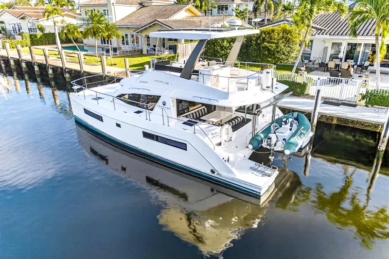  Yacht Photos Pics 2017 Leopard 43 Powercat yacht docked by waterfront homes, featuring sleek design and inflatable tender.