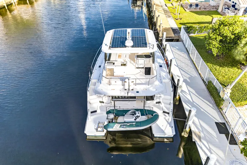  Yacht Photos Pics 2017 Leopard 43 Powercat docked, featuring solar panels and a small boat on the stern.