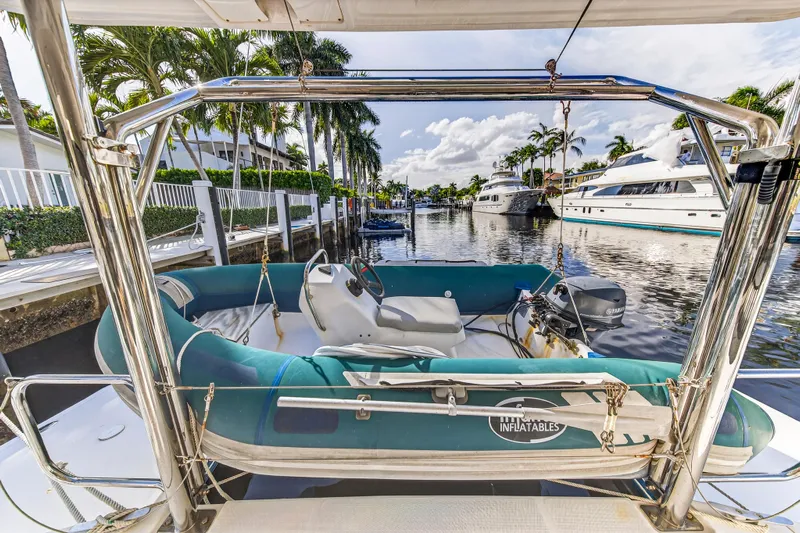  Yacht Photos Pics 2017 Leopard 43 Powercat with inflatable boat on deck, docked in a scenic marina.