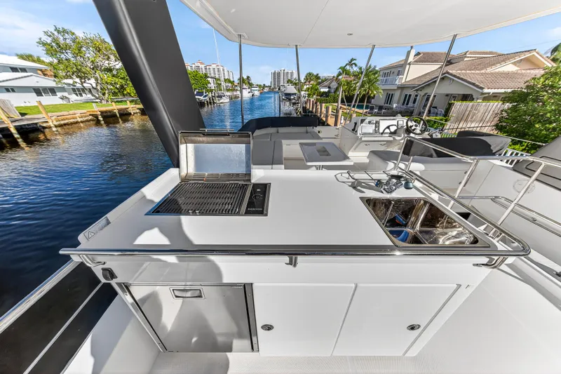  Yacht Photos Pics Outdoor kitchen on 2017 Leopard 43 Powercat yacht with grill and sink, docked by waterfront homes.