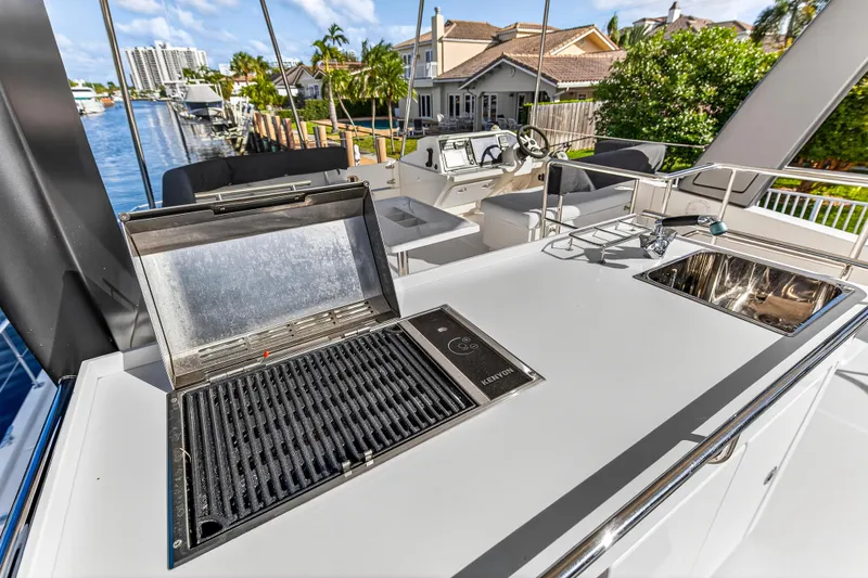  Yacht Photos Pics Outdoor kitchen on 2017 Leopard 43 Powercat yacht with grill and sink, docked by waterfront homes.