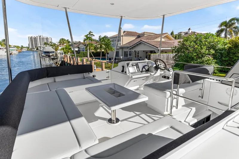  Yacht Photos Pics Luxurious 2017 Leopard 43 Powercat yacht interior with modern helm and seating, docked by waterfront homes.